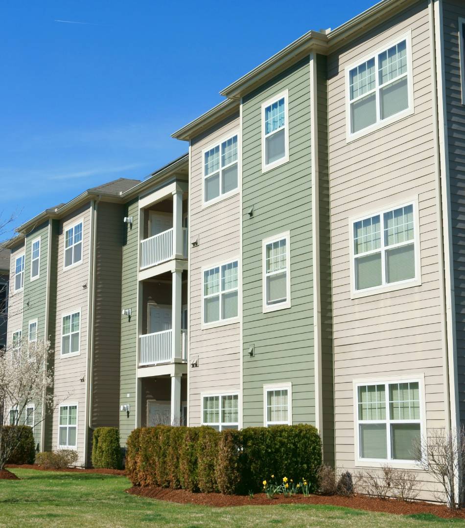 Modern apartment building with varied exterior colors and balconies under a clear blue sky.